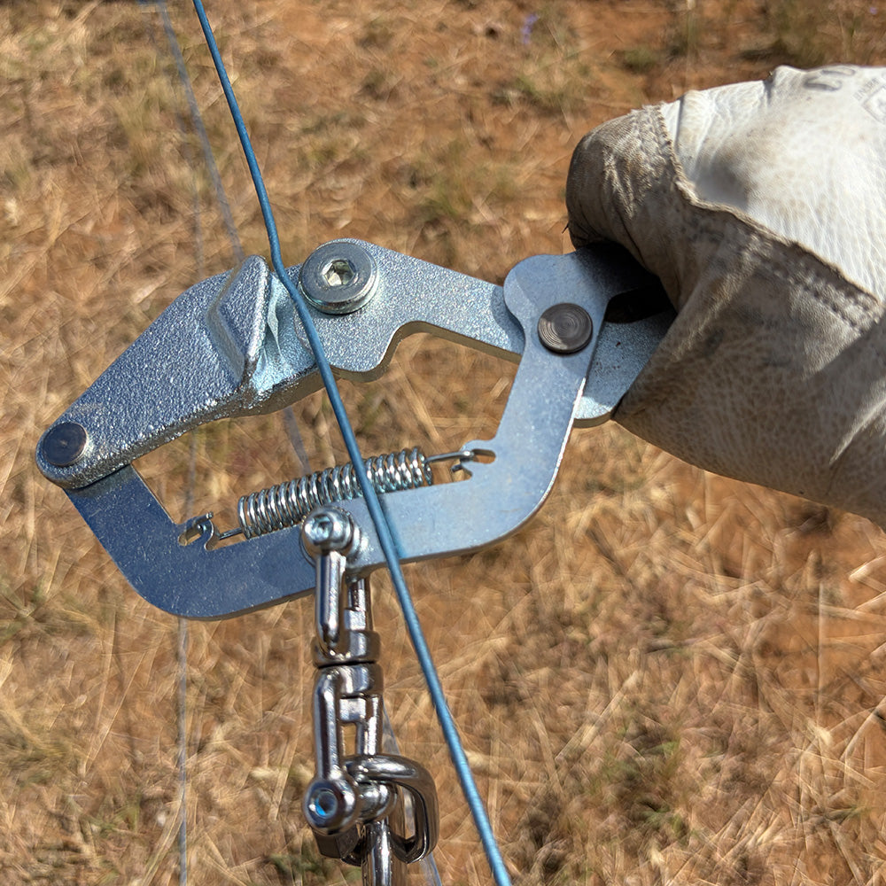 agricultural fencing wire gripper with rabbit ear handles being removed from wire